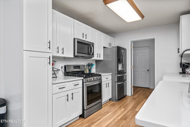 2236 Spruce Loop, Crossville, TN 38555 - kitchen with stainless steel appliances, light countertops, white cabinets, and light wood-style floors