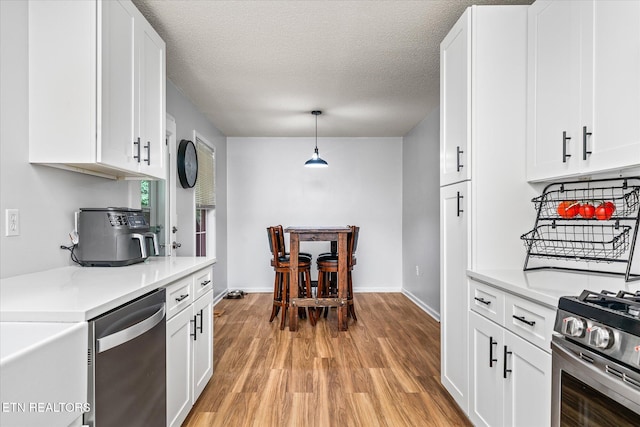 2236 Spruce Loop, Crossville, TN 38555 - kitchen featuring stainless steel appliances, light wood-style flooring, light countertops, white cabinets, and a textured ceiling