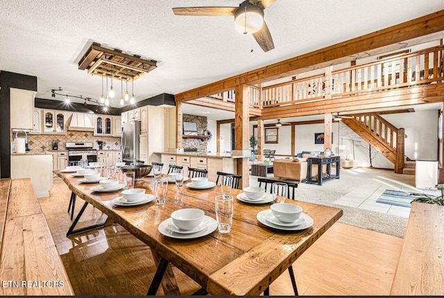 1293 Laurel Lick Rd, Sevierville, TN 37862 - dining room with ceiling fan, light wood-style flooring, a textured ceiling, stairs, and rail lighting