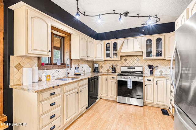 1293 Laurel Lick Rd, Sevierville, TN 37862 - kitchen featuring stainless steel appliances, a sink, custom range hood, light wood-style flooring, and light stone counters