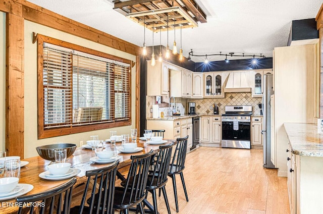 1293 Laurel Lick Rd, Sevierville, TN 37862 - kitchen featuring stainless steel stove, custom range hood, light wood-style floors, glass insert cabinets, and backsplash