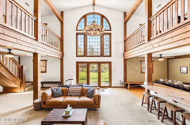 1293 Laurel Lick Rd, Sevierville, TN 37862 - carpeted living room featuring a ceiling fan, a towering ceiling, healthy amount of natural light, a chandelier, and stairway