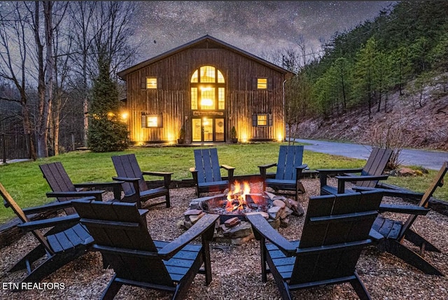1293 Laurel Lick Rd, Sevierville, TN 37862 - back of property with an outdoor fire pit, board and batten siding, and a yard