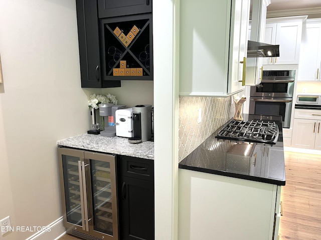 101 Dudala Way, Loudon, TN 37774 - bar area with wine cooler, black gas cooktop, stainless steel double oven, light wood finished floors, and decorative backsplash