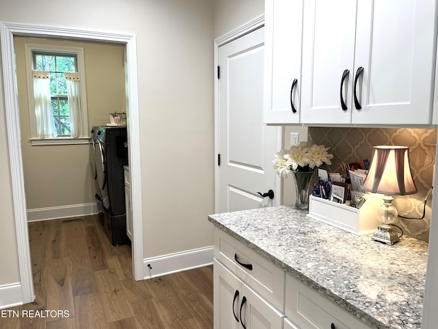 101 Dudala Way, Loudon, TN 37774 - kitchen featuring wood finished floors, independent washer and dryer, baseboards, and white cabinets