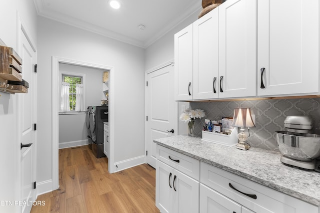 101 Dudala Way, Loudon, TN 37774 - kitchen featuring washing machine and dryer, light wood-style flooring, tasteful backsplash, crown molding, and white cabinetry