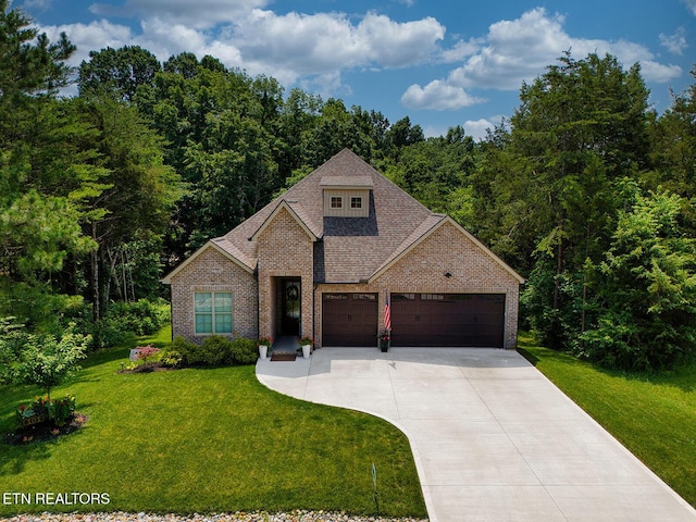 101 Dudala Way, Loudon, TN 37774 - traditional-style home featuring an attached garage, concrete driveway, a front yard, brick siding, and a view of trees