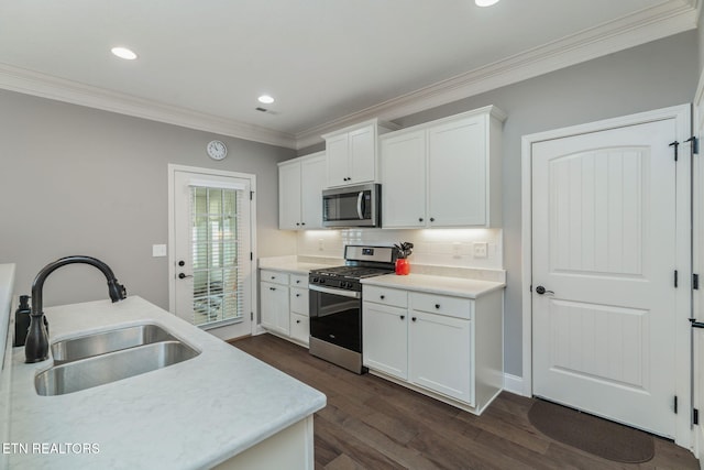 128 Hackberry St, Oak Ridge, TN 37830 - kitchen featuring appliances with stainless steel finishes, a sink, ornamental molding, dark wood-type flooring, and decorative backsplash