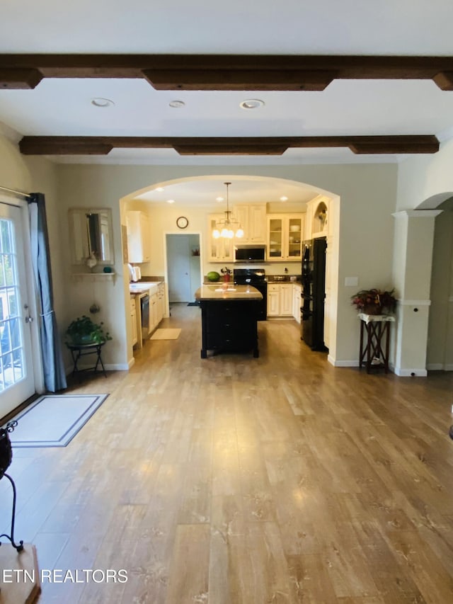 318 Deer Trail Dr, Dandridge, TN 37725 - kitchen with arched walkways, black appliances, beamed ceiling, a center island, and wood finished floors