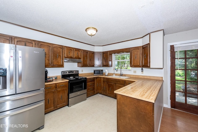 1502 Woodbury Ct, Maryville, TN 37803 - kitchen featuring appliances with stainless steel finishes, a sink, a textured ceiling, under cabinet range hood, and a peninsula