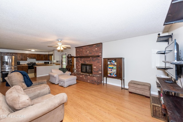 1502 Woodbury Ct, Maryville, TN 37803 - living area with light wood-style flooring, a ceiling fan, a textured ceiling, and a brick fireplace