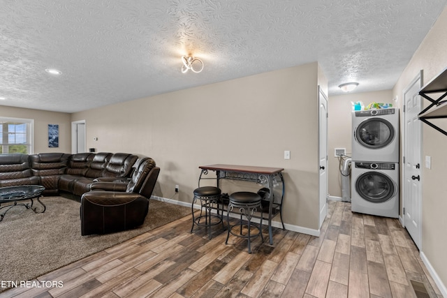 2055 Scott St, Sevierville, TN 37876 - living area featuring stacked washer / dryer, a textured ceiling, wood finished floors, and baseboards
