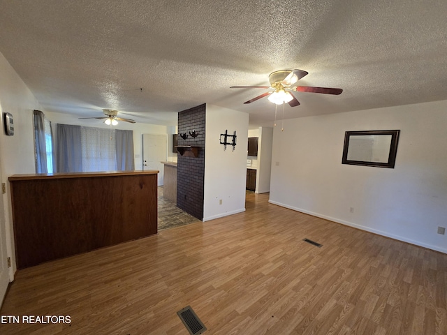 288 Machine Branch Rd, Ewing, VA 24248 - unfurnished living room with a ceiling fan, wood finished floors, a textured ceiling, and baseboards
