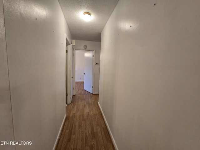 288 Machine Branch Rd, Ewing, VA 24248 - corridor featuring wood finished floors, baseboards, and a textured ceiling