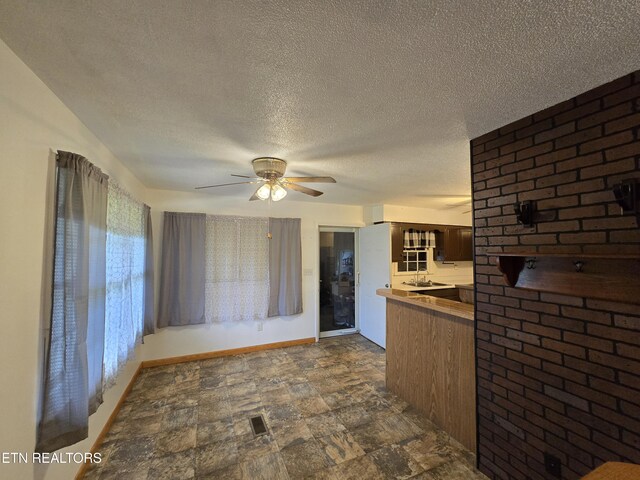 288 Machine Branch Rd, Ewing, VA 24248 - kitchen featuring a ceiling fan, stone finish flooring, baseboards, a textured ceiling, and dark brown cabinets