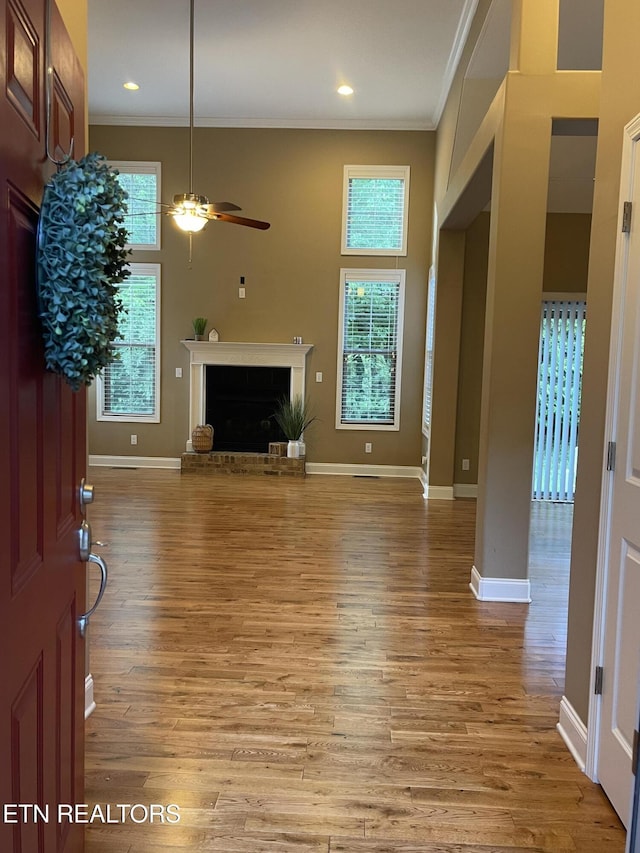 103 Crossroads Blvd, Oak Ridge, TN 37830 - unfurnished living room featuring a fireplace, ornamental molding, ceiling fan, light wood-style floors, and baseboards