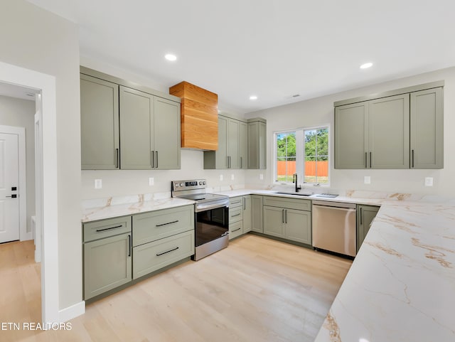 7747 Drawbridge Ct, Powell, TN 37849 - kitchen featuring appliances with stainless steel finishes, a sink, light stone counters, light wood finished floors, and recessed lighting