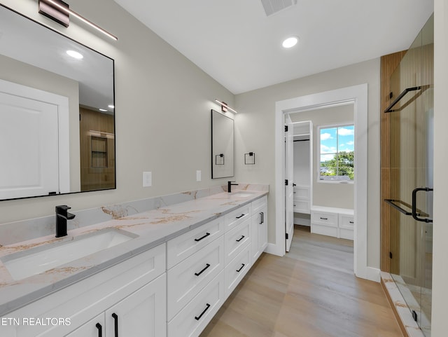 7747 Drawbridge Ct, Powell, TN 37849 - bathroom with double vanity, a shower stall, wood finished floors, recessed lighting, and baseboards