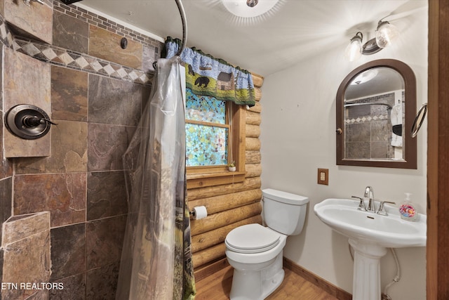 3509 Ginseng Way, Sevierville, TN 37862 - bathroom with log walls, wood finished floors, toilet, a tile shower, and baseboards