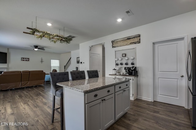 12017 Spearmint Ln, Knoxville, TN 37932 - kitchen featuring a breakfast bar area, ceiling fan, freestanding refrigerator, open floor plan, and dark wood finished floors