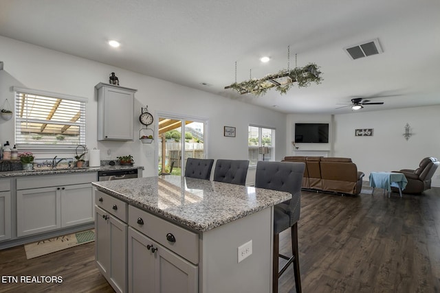 12017 Spearmint Ln, Knoxville, TN 37932 - kitchen with a sink, a kitchen island, a breakfast bar, gray cabinetry, and dark wood-style floors