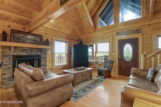 2405 Autumn Valley Way, Pigeon Forge, TN 37862 - living area with wood walls, plenty of natural light, light wood-type flooring, wooden ceiling with exposed beams, and a stone fireplace