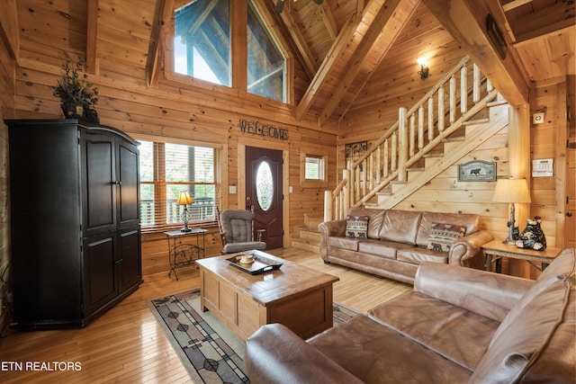 2405 Autumn Valley Way, Pigeon Forge, TN 37862 - living room with wooden walls, wood ceiling with exposed beams, stairs, healthy amount of natural light, and light wood-style floors
