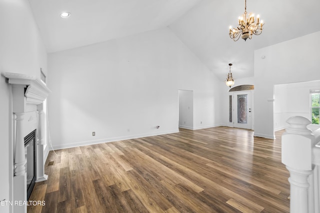 128 Harbour View Way, Kingston, TN 37763 - unfurnished living room featuring high vaulted ceiling, a chandelier, a glass covered fireplace, wood finished floors, and baseboards