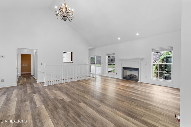 128 Harbour View Way, Kingston, TN 37763 - unfurnished living room featuring high vaulted ceiling, a chandelier, wood finished floors, a glass covered fireplace, and recessed lighting