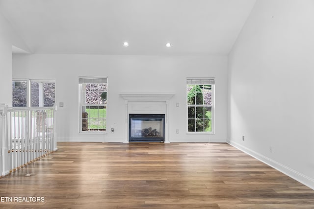 128 Harbour View Way, Kingston, TN 37763 - unfurnished living room featuring wood finished floors, a glass covered fireplace, recessed lighting, baseboards, and vaulted ceiling