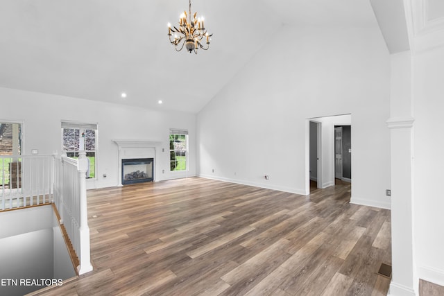 128 Harbour View Way, Kingston, TN 37763 - unfurnished living room with high vaulted ceiling, a chandelier, wood finished floors, a fireplace, and recessed lighting
