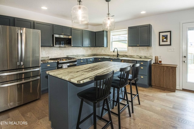 3250 Truitt Path Ln, Knoxville, TN 37931 - kitchen featuring stainless steel appliances, a sink, a kitchen bar, light wood-type flooring, and tasteful backsplash