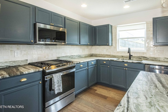 3250 Truitt Path Ln, Knoxville, TN 37931 - kitchen featuring stainless steel appliances, a sink, dark wood finished floors, light stone counters, and backsplash