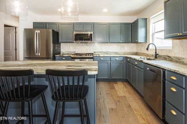 3250 Truitt Path Ln, Knoxville, TN 37931 - kitchen featuring stainless steel appliances, a kitchen bar, light wood finished floors, a sink, and backsplash