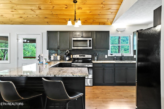 3050 Patty View Way, Sevierville, TN 37862 - kitchen with appliances with stainless steel finishes, a sink, light wood-style flooring, pendant lighting, and light stone counters