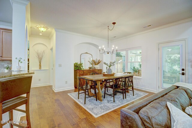 192 Saloli Way, Loudon, TN 37774 - dining space with wood finished floors, a chandelier, ornamental molding, and arched walkways