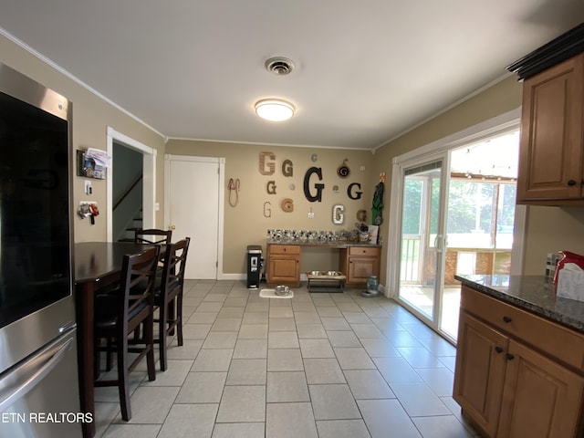 106 Apache Rd, Maryville, TN 37804 - kitchen with fridge, ornamental molding, light tile patterned flooring, baseboards, and dark stone counters