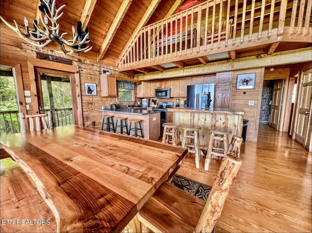 2438 Walnut Ridge Way, Sevierville, TN 37862 - dining space with high vaulted ceiling, wooden walls, light wood-style floors, wooden ceiling with exposed beams, and a chandelier