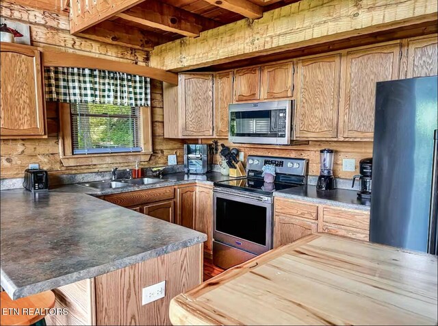 2438 Walnut Ridge Way, Sevierville, TN 37862 - kitchen featuring stainless steel appliances, a sink, dark countertops, wooden ceiling with exposed beams, and a peninsula