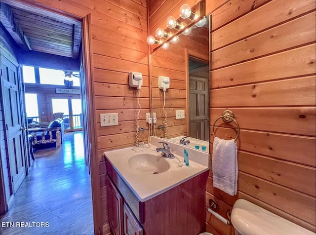 2438 Walnut Ridge Way, Sevierville, TN 37862 - half bath featuring vanity, wooden walls, toilet, and wood finished floors