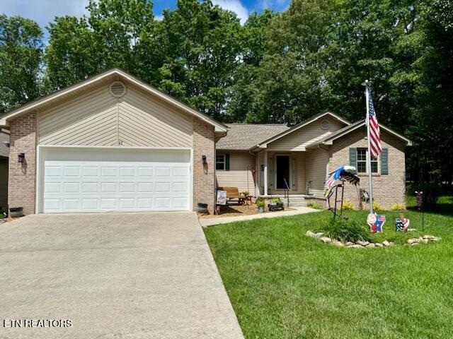 15 Felix Ct, Crossville, TN 38558 - ranch-style house featuring concrete driveway, a garage, brick siding, and a front lawn