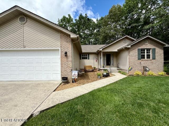 15 Felix Ct, Crossville, TN 38558 - single story home with brick siding, driveway, a garage, and a front yard