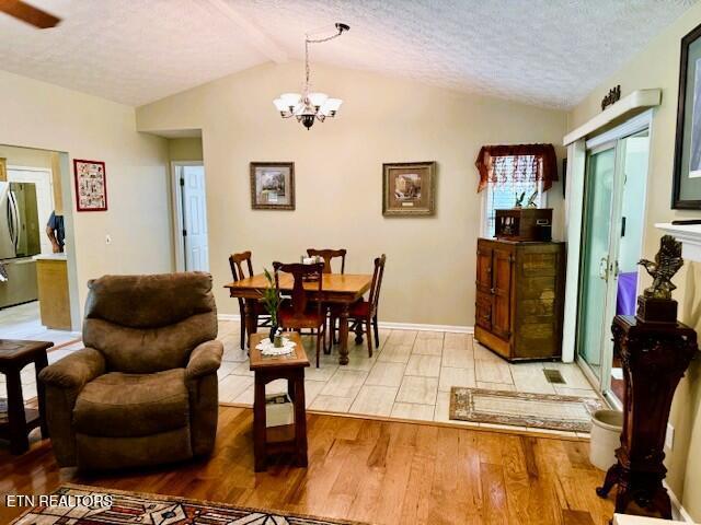 15 Felix Ct, Crossville, TN 38558 - dining room with vaulted ceiling, light wood finished floors, a textured ceiling, and a chandelier
