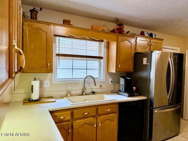 15 Felix Ct, Crossville, TN 38558 - kitchen with freestanding refrigerator, a sink, a textured ceiling, light countertops, and black dishwasher