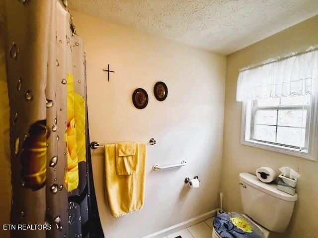 15 Felix Ct, Crossville, TN 38558 - bathroom featuring a textured ceiling, toilet, tile patterned floors, and baseboards