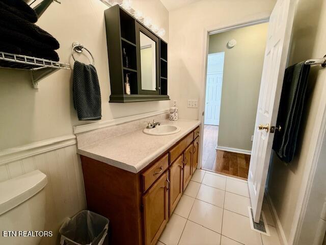 15 Felix Ct, Crossville, TN 38558 - bathroom featuring vanity, toilet, wainscoting, and tile patterned flooring