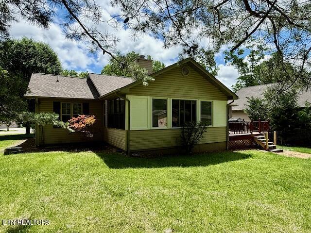 15 Felix Ct, Crossville, TN 38558 - back of house with a chimney, a deck, a yard, and roof with shingles