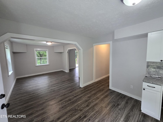 550 N 13th St, Lafollette, TN 37766 - unfurnished living room with dark wood-style floors, baseboards, arched walkways, and a textured ceiling