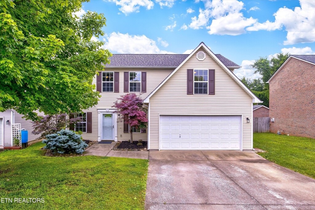 2040 Cartmill Dr, Powell, TN 37849 - traditional-style house featuring driveway, a garage, a front lawn, and a shingled roof