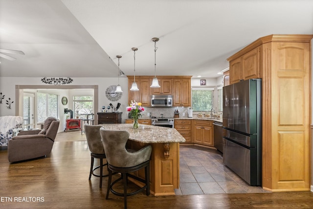 407 Tecumseh Pt, Loudon, TN 37774 - kitchen with stainless steel appliances, a sink, light stone countertops, open floor plan, and a center island